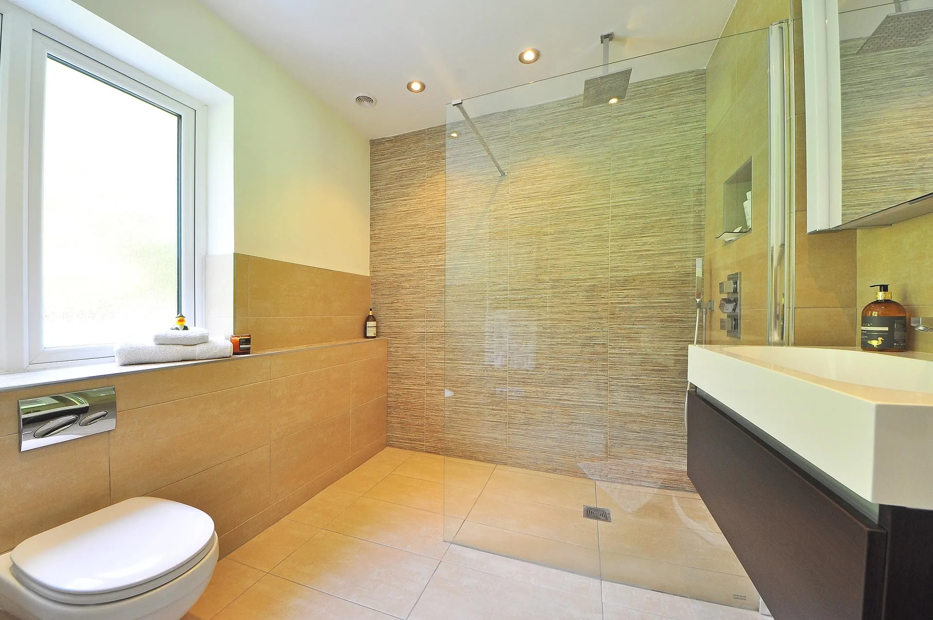 Helles Badezimmer mit bodengleicher Dusche und frischen Handtüchern